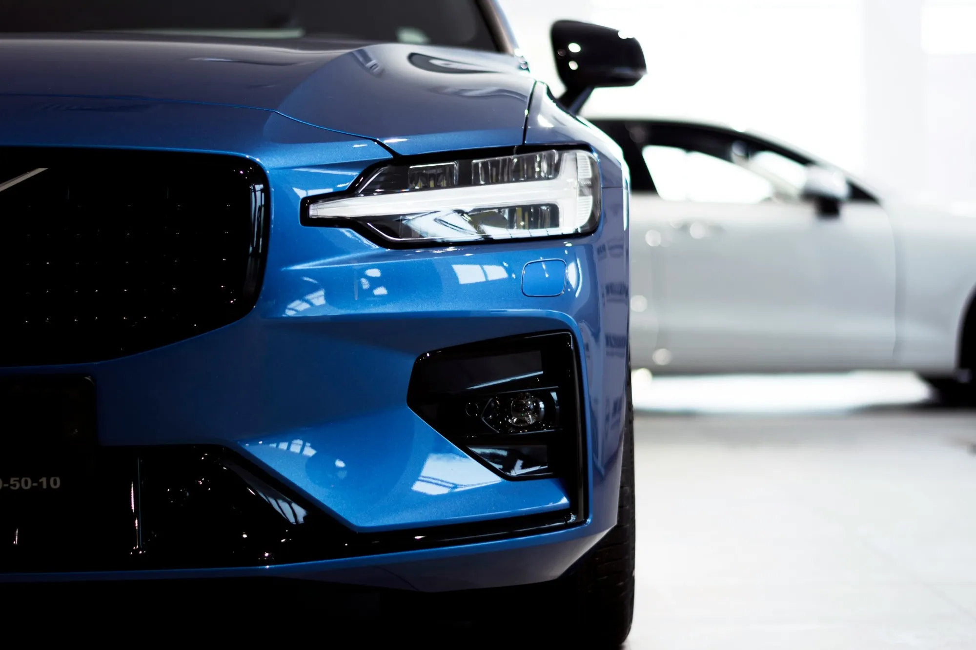 Blue passenger car in a bright showroom