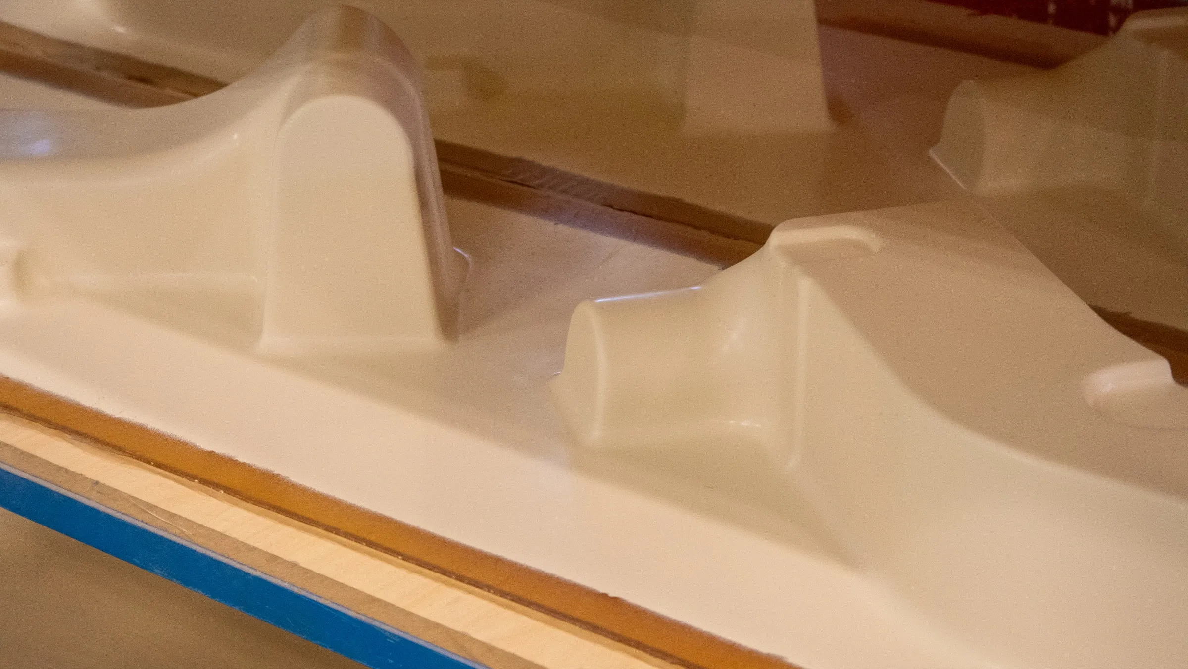 Cream white composite mould details set out on a bench in the workshop