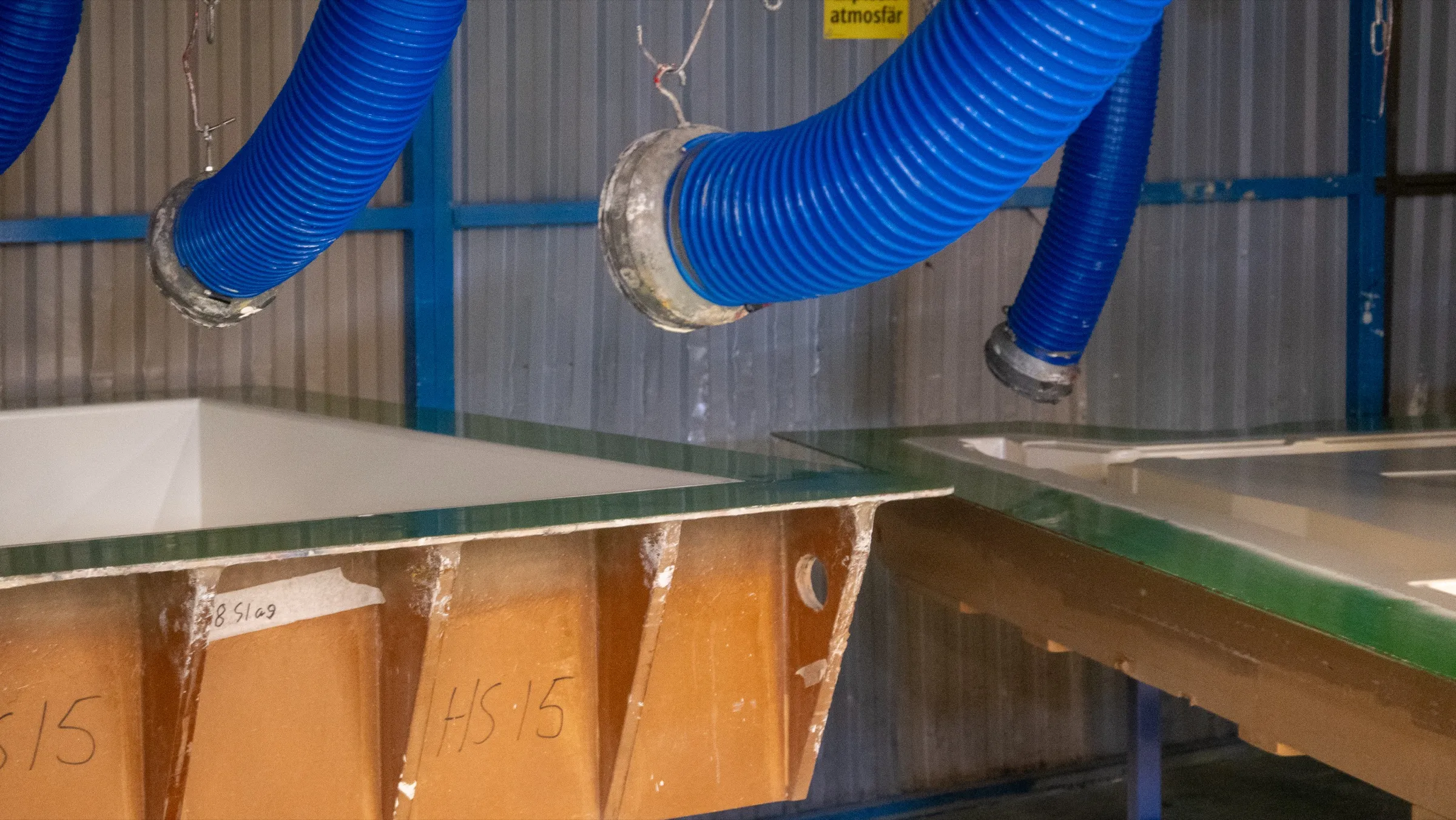 Utsugsslangar över formar i lamineringsrummet